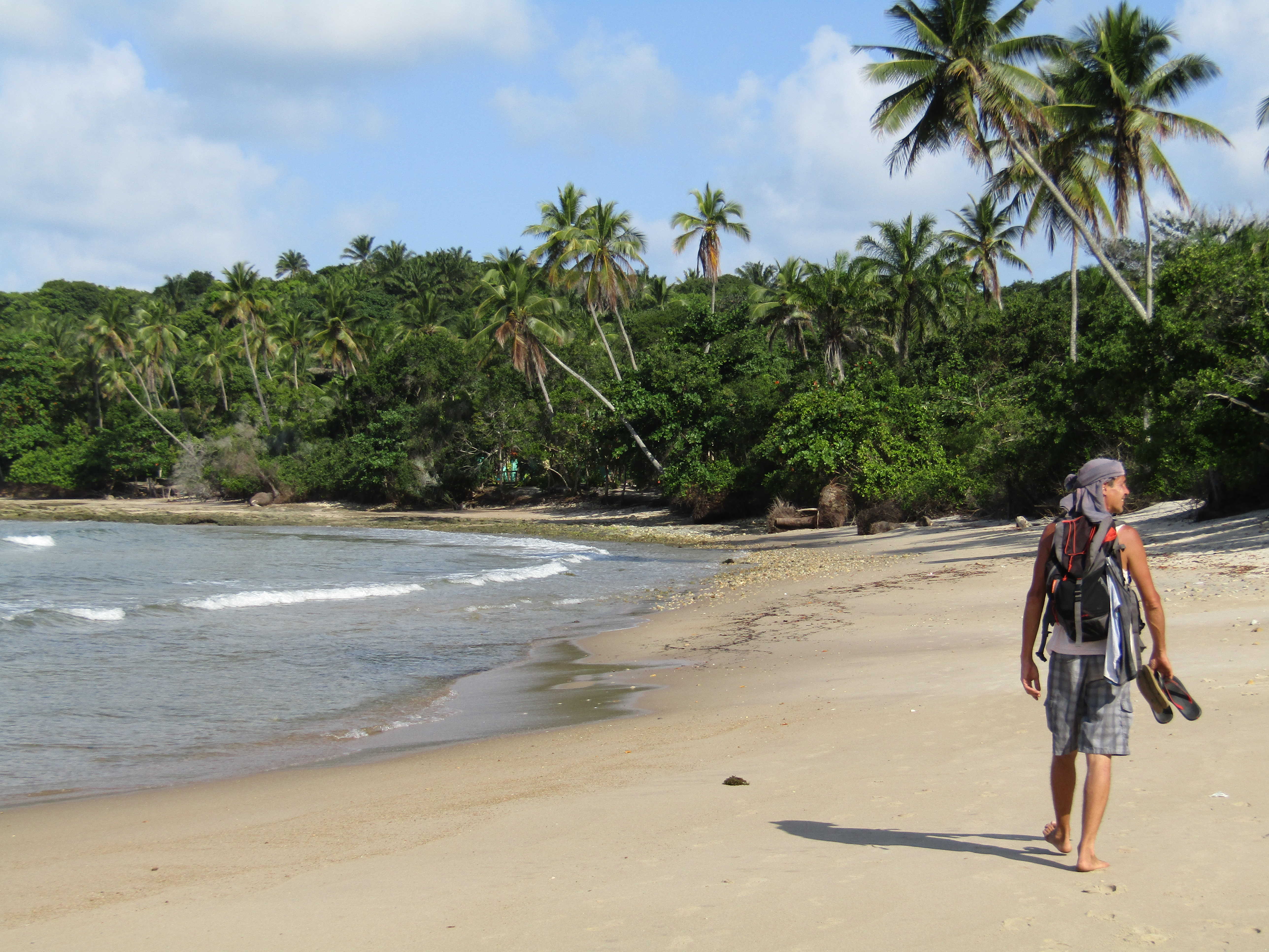 Homme marchant sur une plage de l'île de Boipeba