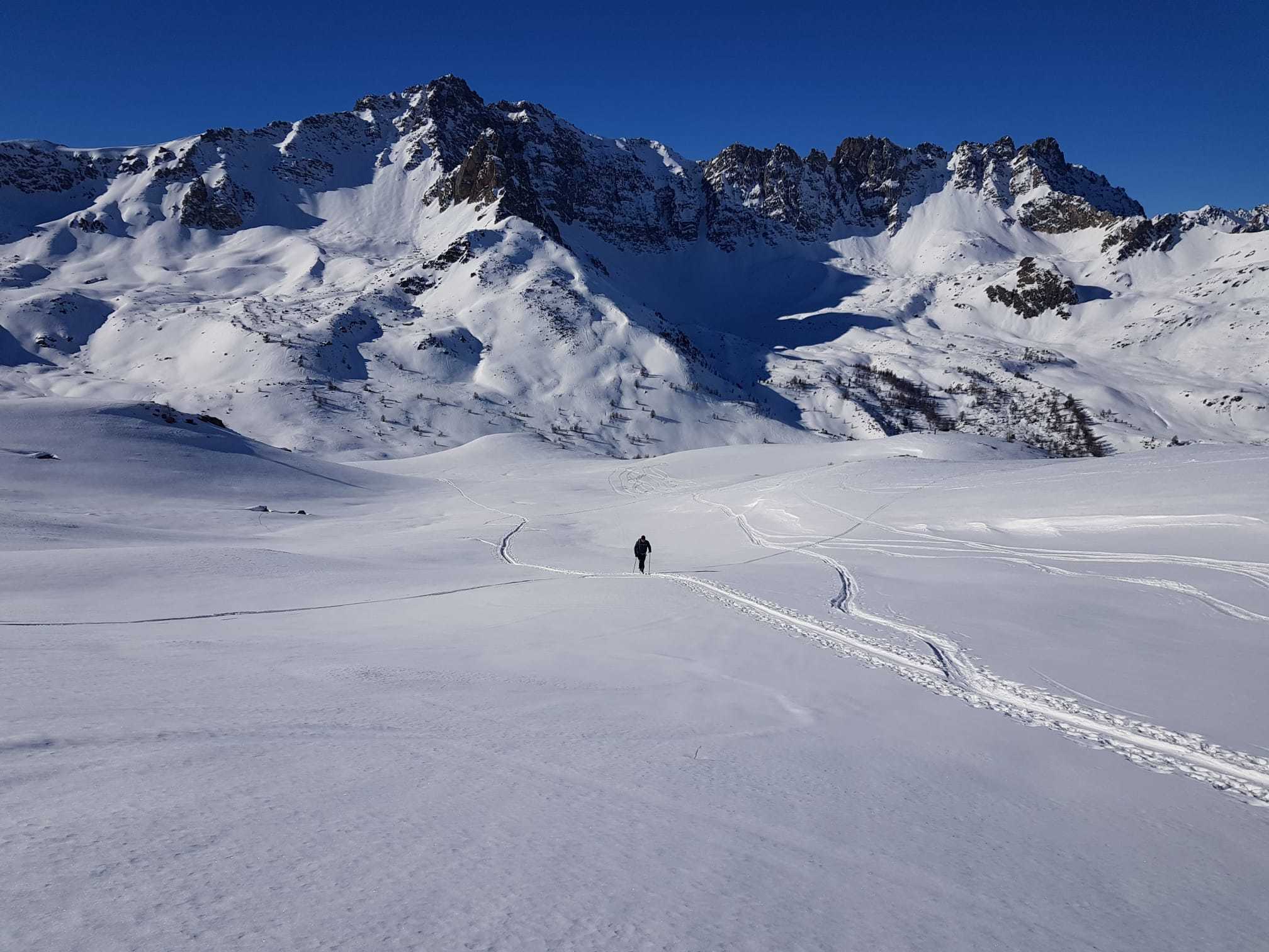 Skieur traverse plaine à ski