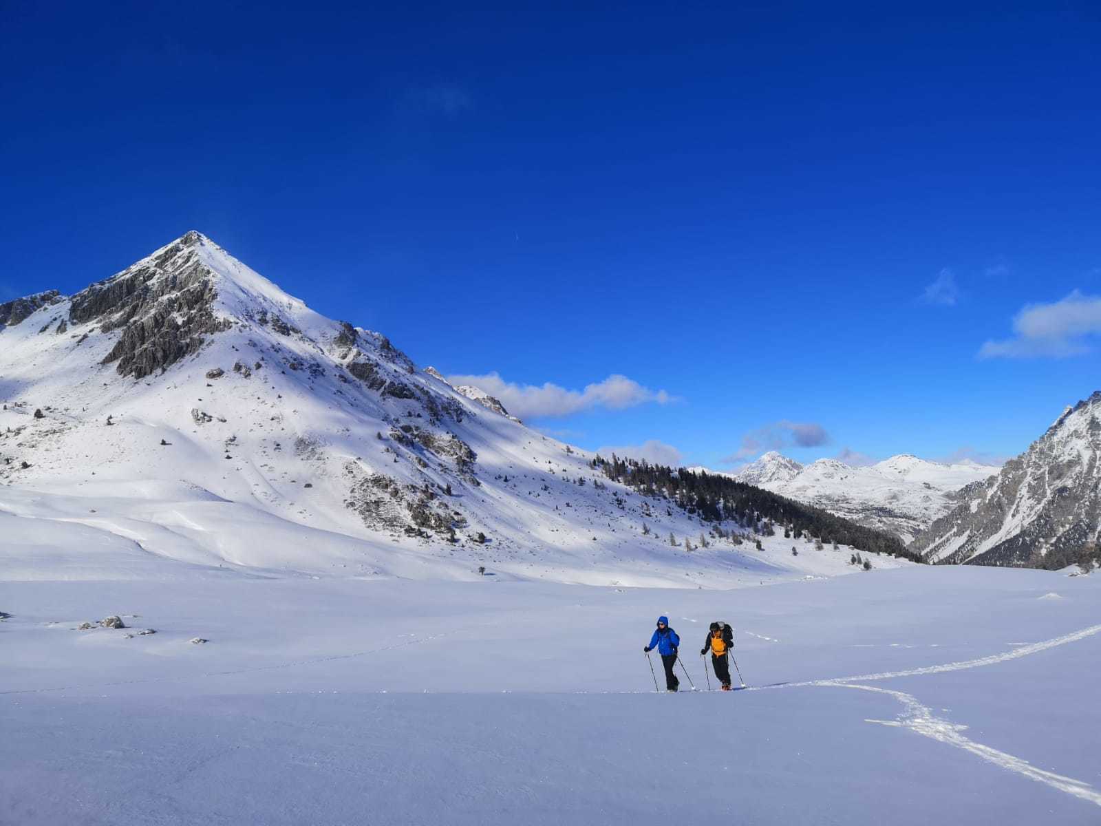 Skieurs de randonnée dans une plaine enneigée