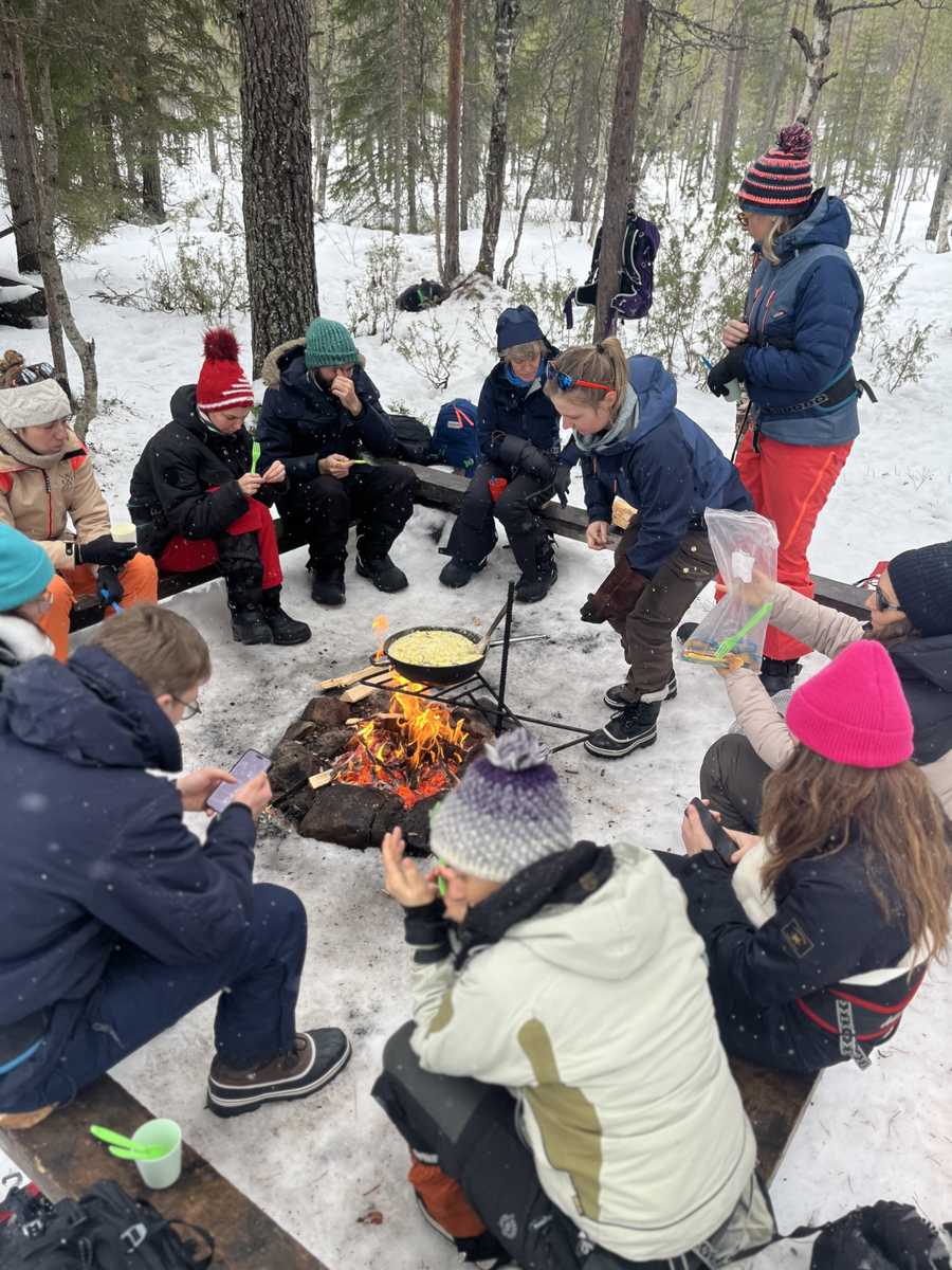 Petit groupe de voyageurs autour d'un feu pendant une repas en Finalnde