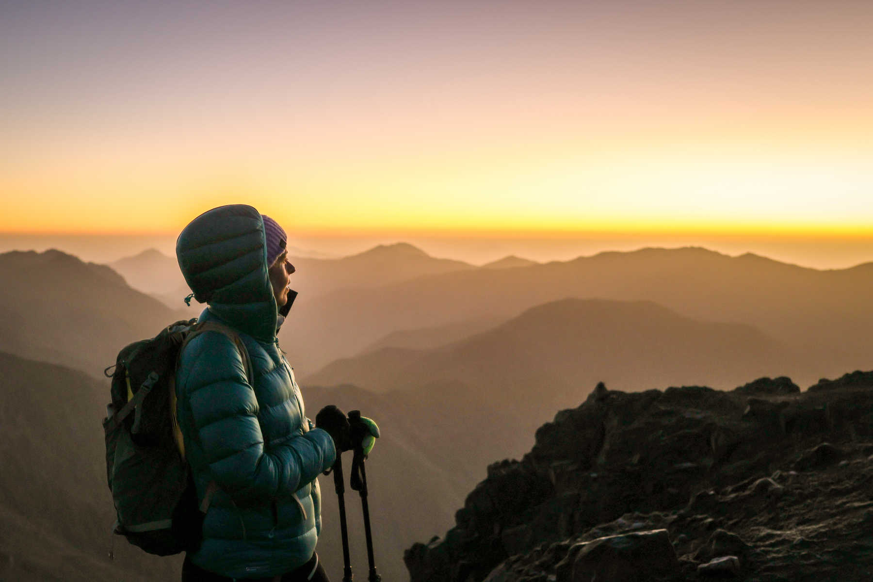 Randonneuse au lever de soleil au sommet du Toubkal au Maroc