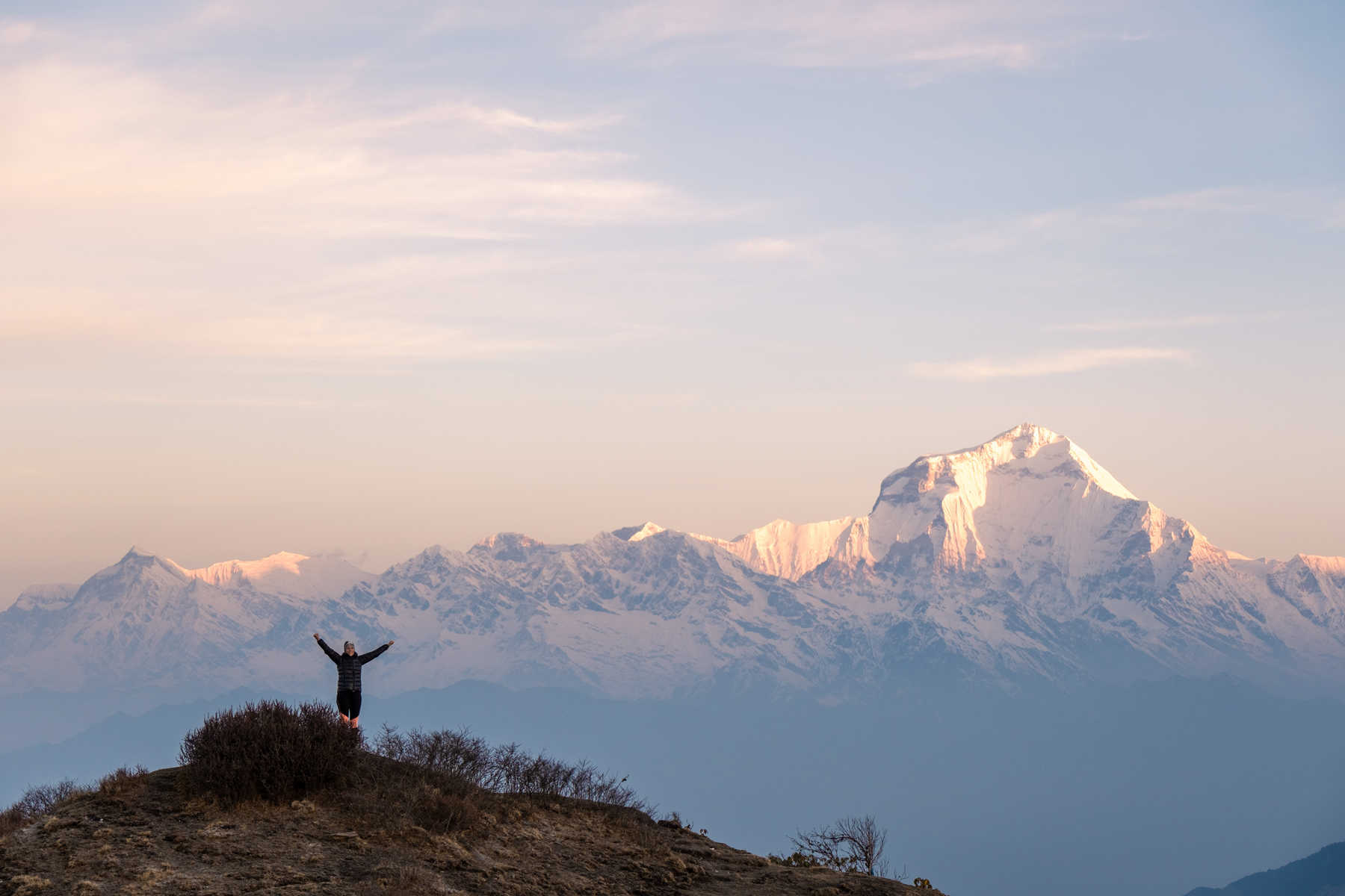 Randonneuse célèbrant son arrivée au sommet d'une montagne devant le mont Dhaulagiri au Népal