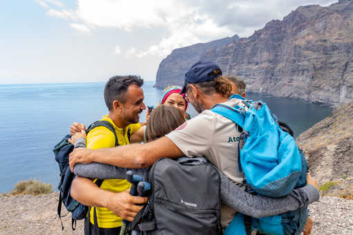 groupe de randonneurs qui se font un calin devant la falaise de los Gigantes sur l'ile de Tenerife