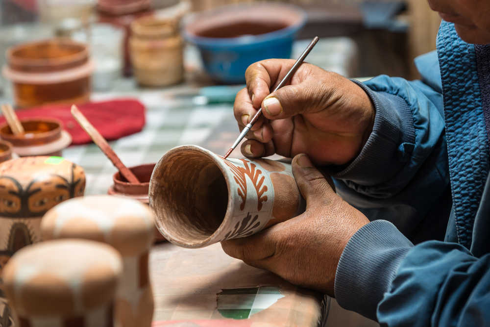 Artisan en train de peindre de la poterie au Pérou