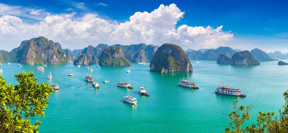 Baie de Lan Ha, Vietnam, les montagnes sont entourées par l'eau turquoise et les bateaux