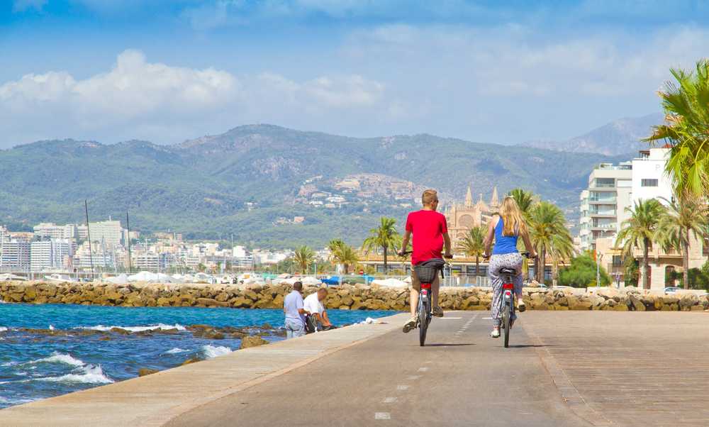 Balade à vélo à Majorque en direction de la cathedral Seu, deux personnes sont de dos sur la piste cyclable