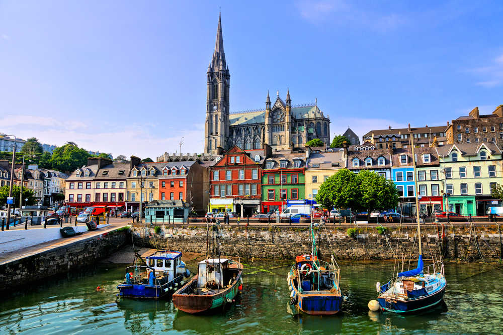 Bâtiments colorés et vieux bateaux avec la cathédrale dans le port de Cobh, comté de Cork, Irlande