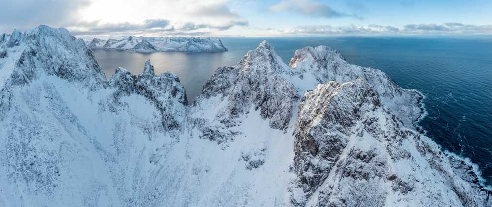 Chaîne de montagnes enneigées sur le littoral en hiver, Norvège. Senja vue aérienne  Norvège