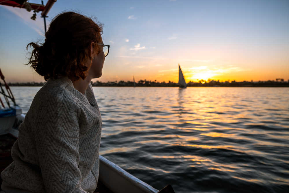 Voyageuse regardant le coucher de soleil sur le Nil