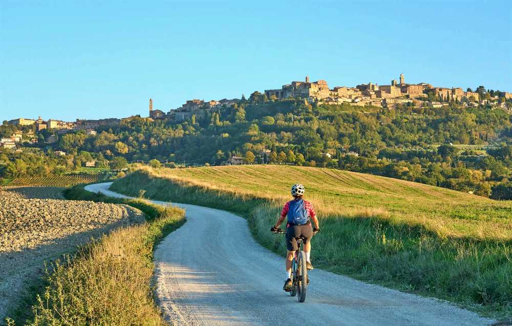 Cycliste en direction du village Montepulciano, Toscane, Italie