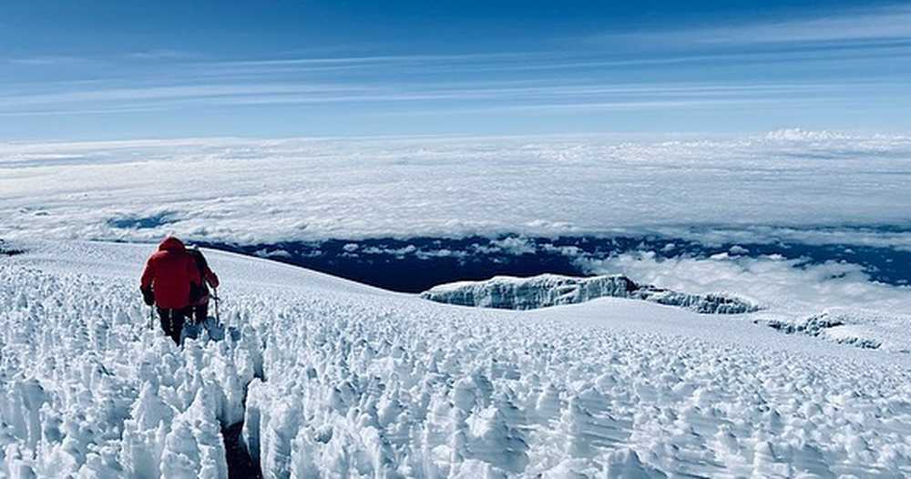 Deux randonneurs les pieds dans la neige lors de la dernière ascension pour atteindre le sommet du Kilimandjaro en Tanzanie