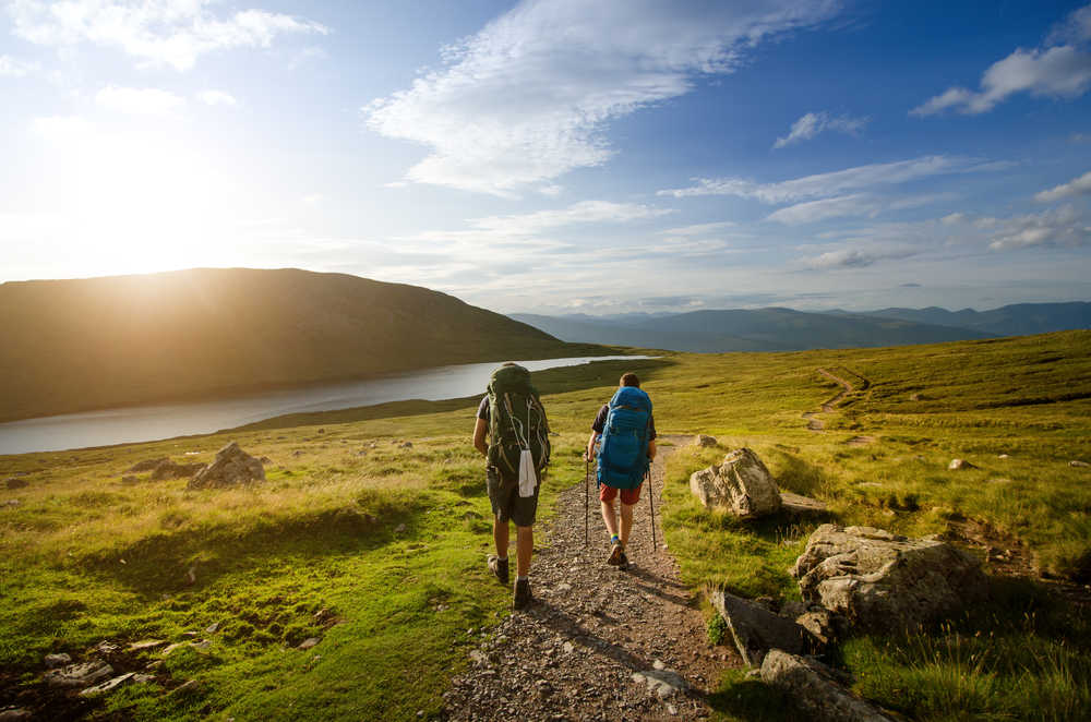 Deux randonneurs se baladent sur l'île de Skye, Ecosse, une grande plaine s'étend devant eux