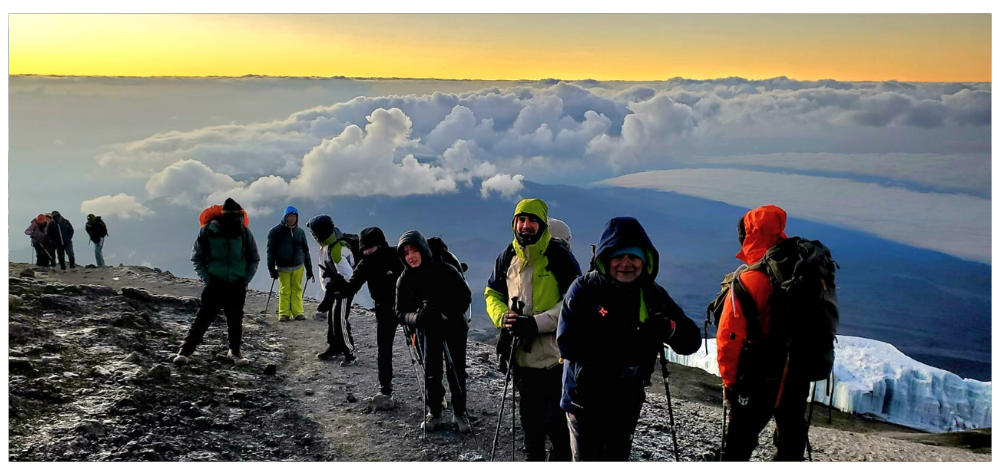 Groupe de randonneurs au lever du soleil devant la vue depuis le sommet du Kilimandjaro en Tanzanie
