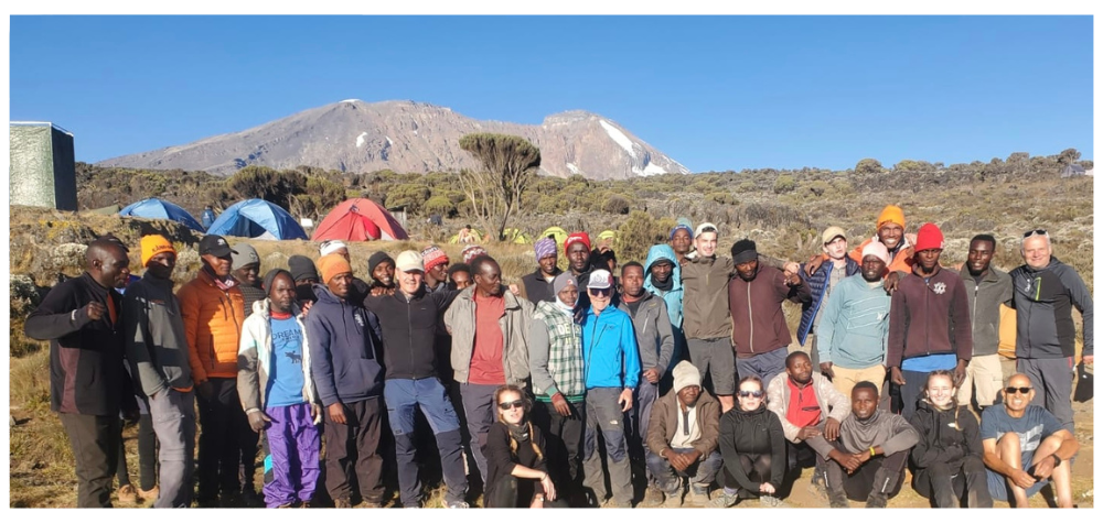 Groupe de randonneurs avec leur équipe composée de guides, de porteurs et de cuisiniers lors de l'ascension du Kilimandjaro, en Tanzanie