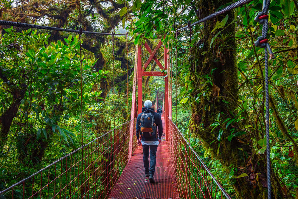 Homme traversant un pont suspendu au Costa Rica