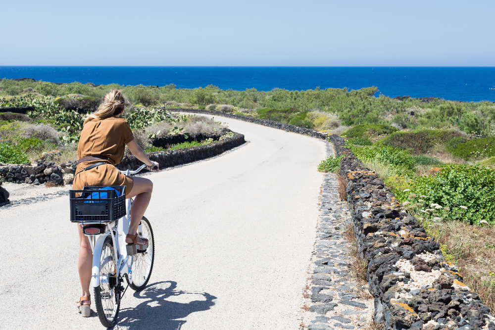 Jeune femme à vélo sur les sentiers de Sicile