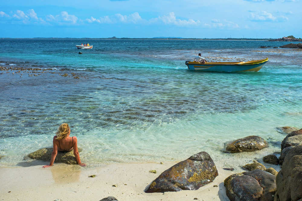 Jeune femme se reposant au bord d'une plage de Pigeon Island au Sri Lanka