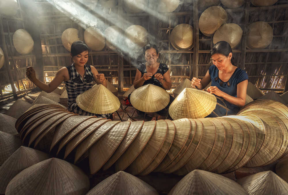 Jeunes femmes travaillant l'artisanat du chapeau conique au Vietnamm