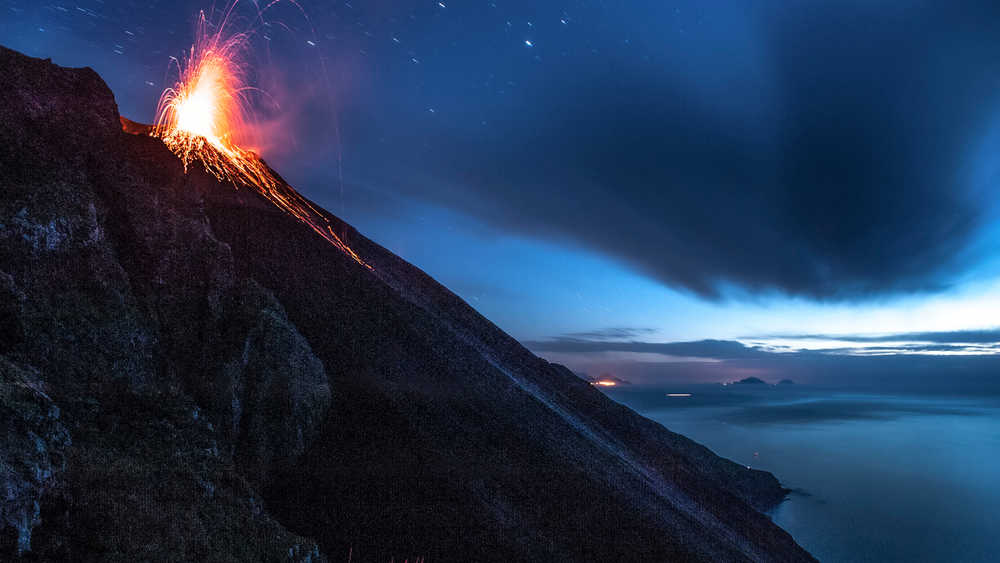 Panorama sur une éruption du volcan Stromboli à la nuit tombée