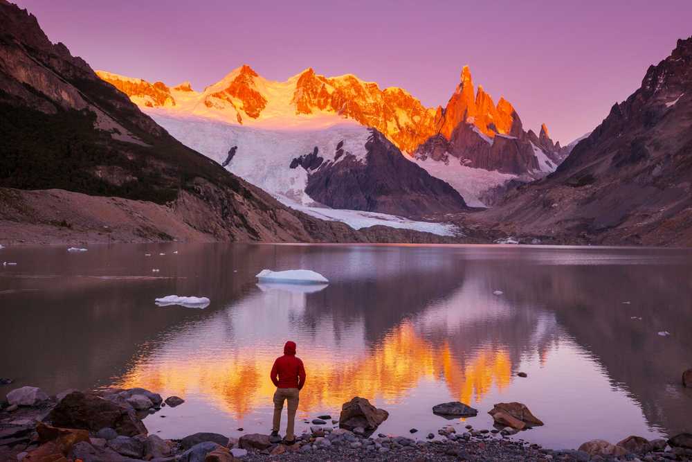 Randonneur devant le Cerro Torre au coucher du soleil, en Patagonie argentine