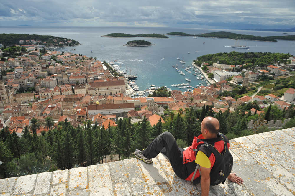 randonneur qui admire la vue depuis le haut d'une ville en Croatie