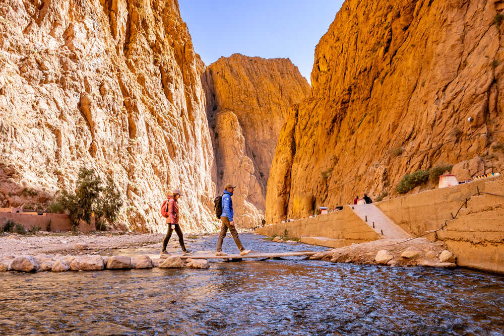 Randonneurs qui traversent la rivière de Toudgha au Maroc