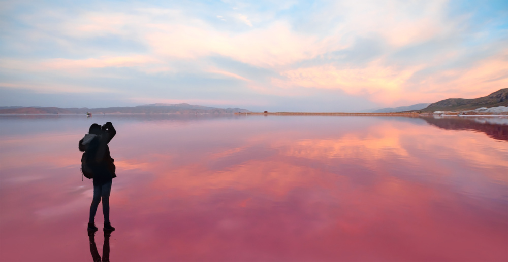randonneuse devant le lac rose Maharlu pendant le coucher du soleil, Shiraz, Iran