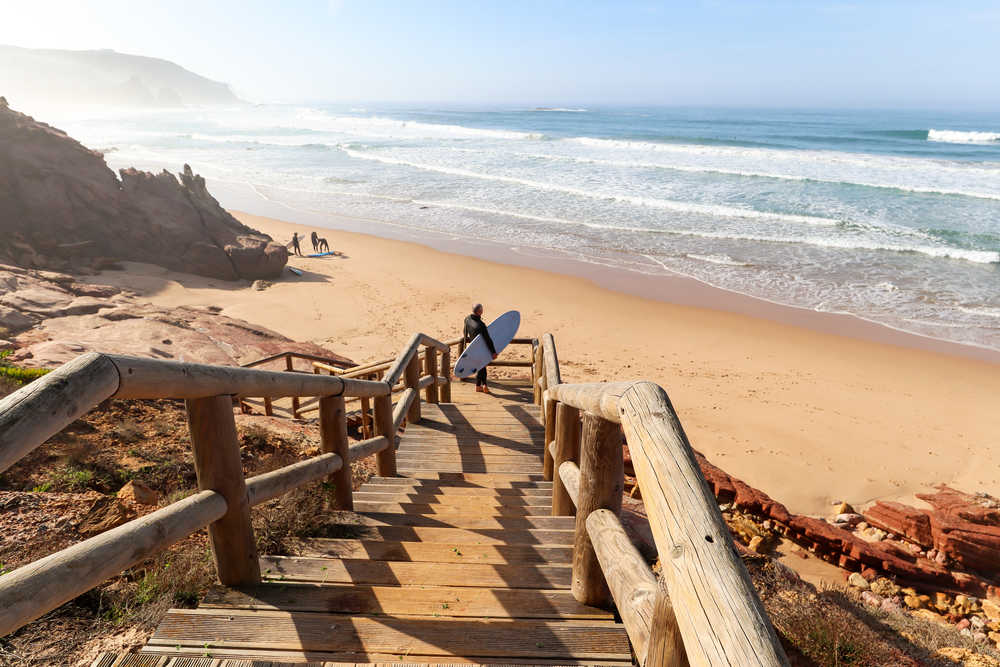 Surfeur descendant sur la plage, Costa Vicentina en Algarve au Portugal