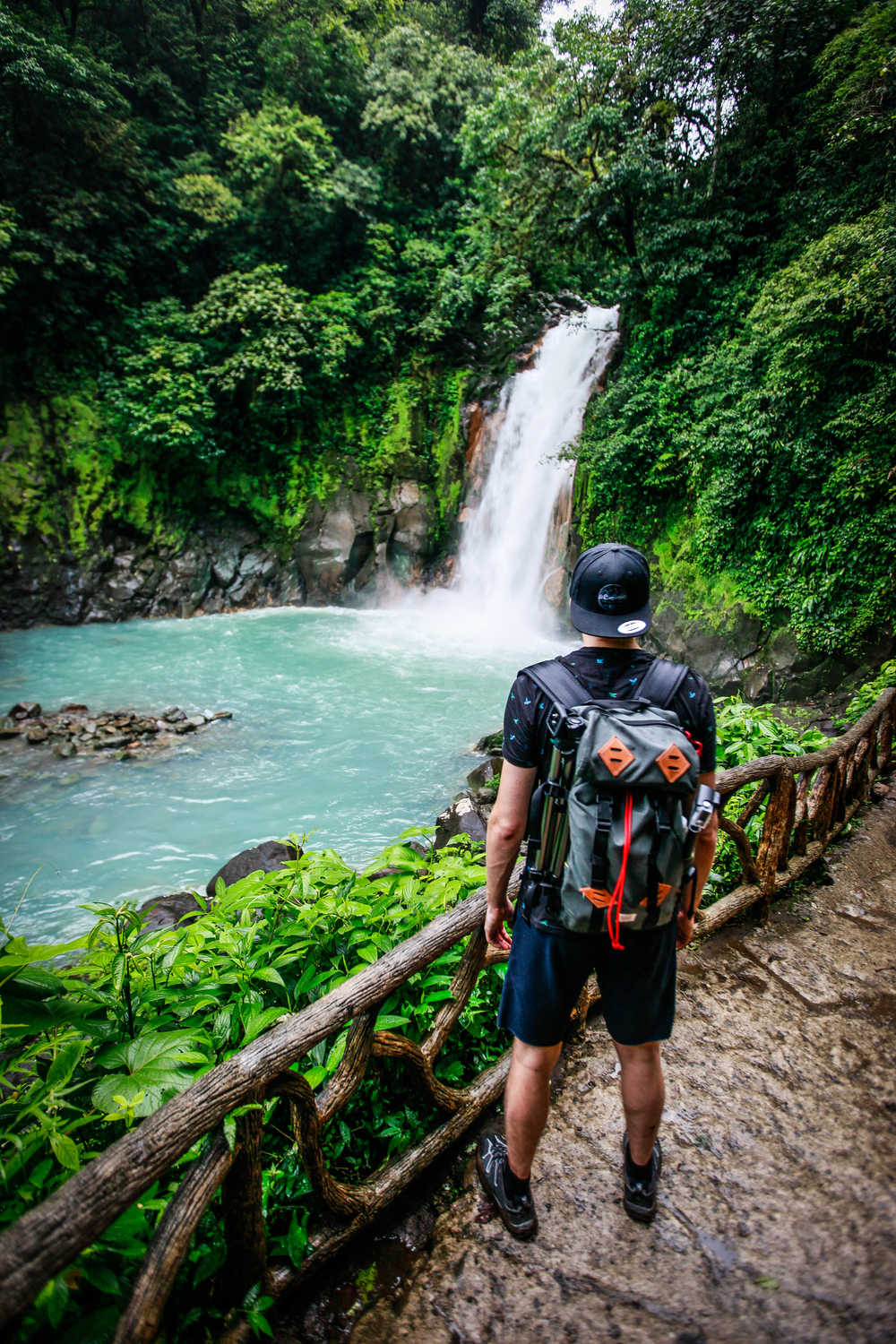 Un randonneur fait face à une cascade au coeur de la jungle au costa rica