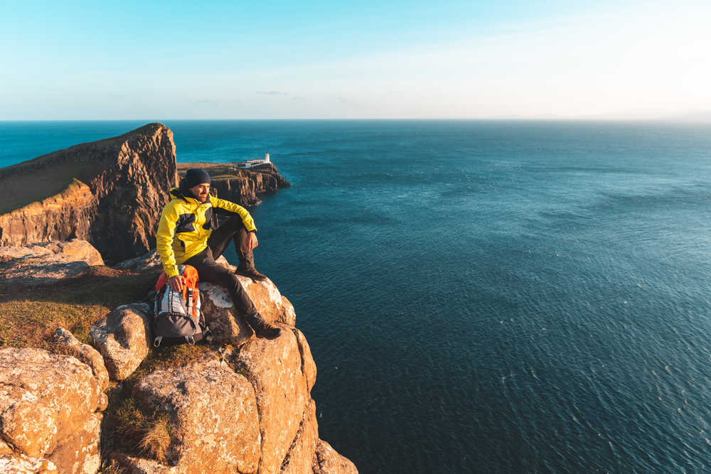 Un randonneur s'est posé au sommet du falaise en Ecosse, il a une vue sur la mer