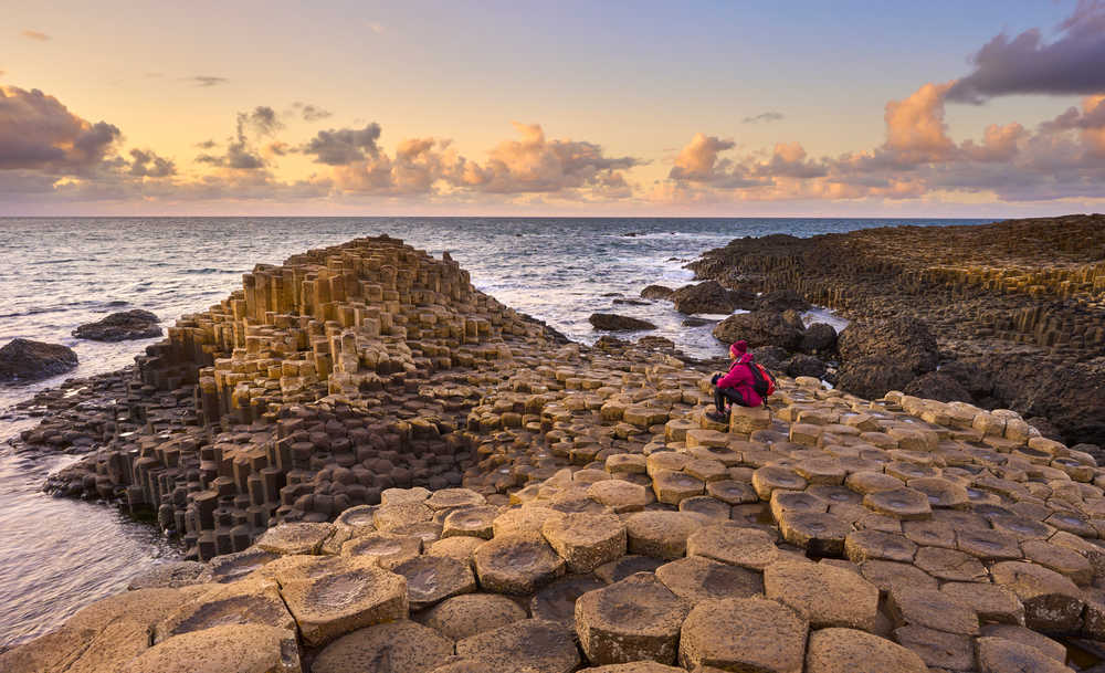 Voyageur profitant de la vue sur la mer à la Chaussée des Géants, Irlande