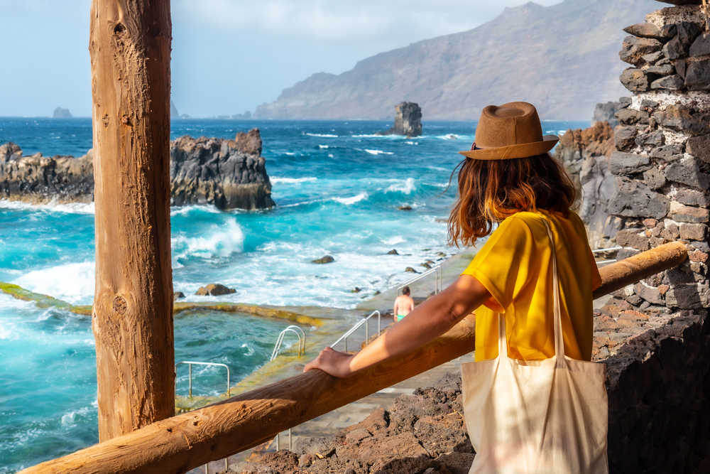 Voyageuse de dos observant l'océan sur l'île d'El Hierro aux Canaries
