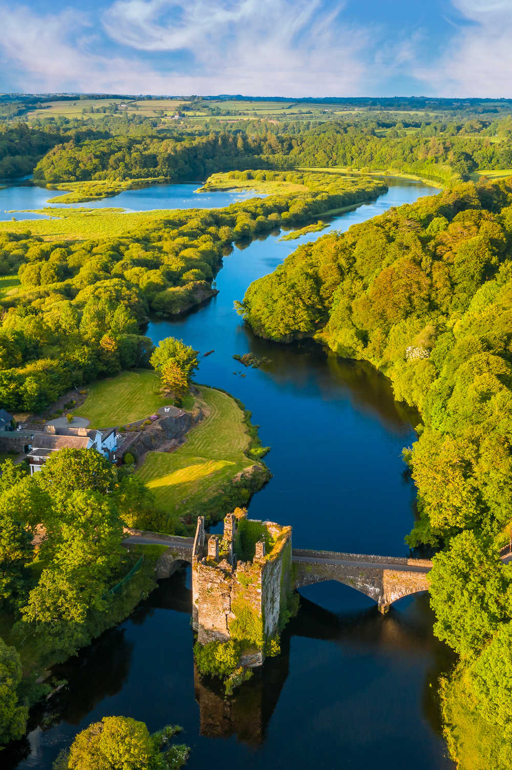 Vue aérienne sur une rivière au coucher de soleil avec vue sur un pont en ruines, Irlande