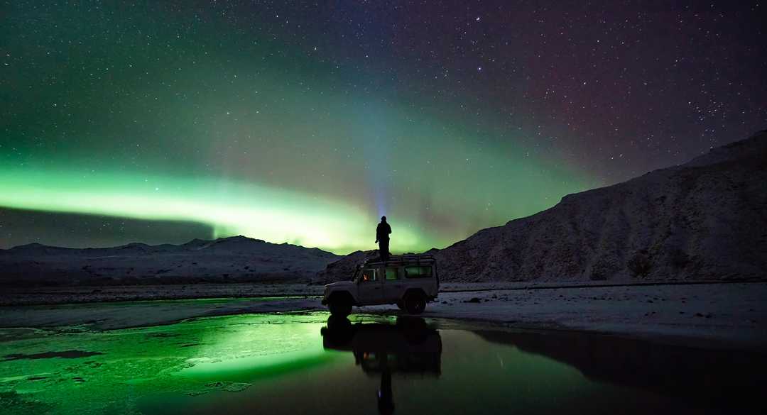 Aurore boréale en Islande - © Unsplash Unsplash Photo d'une personne sous les aurores boréales