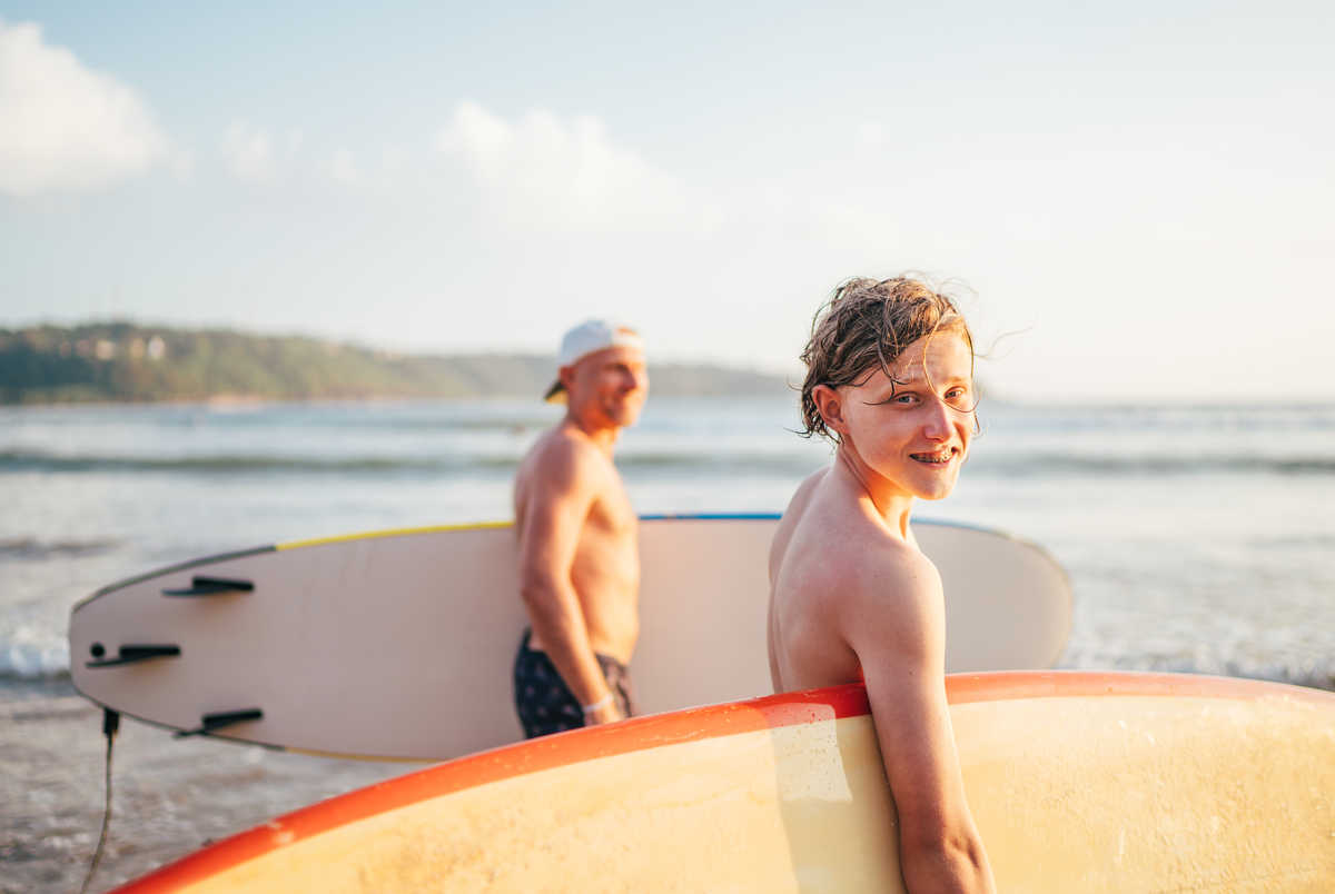 Ado en famille faisant du surf à la plage
