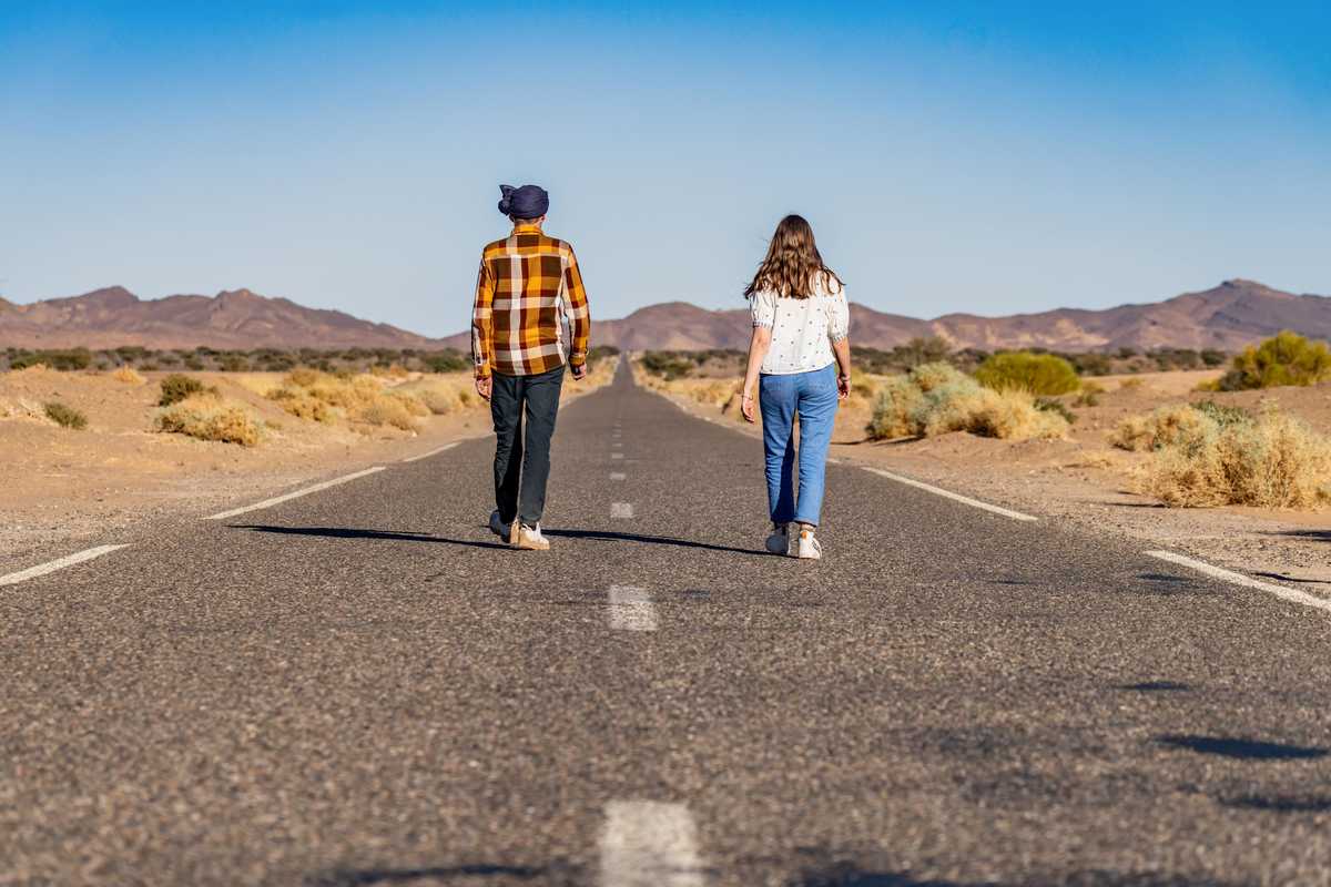 Deux voyageurs qui marchent sur une route au Maroc