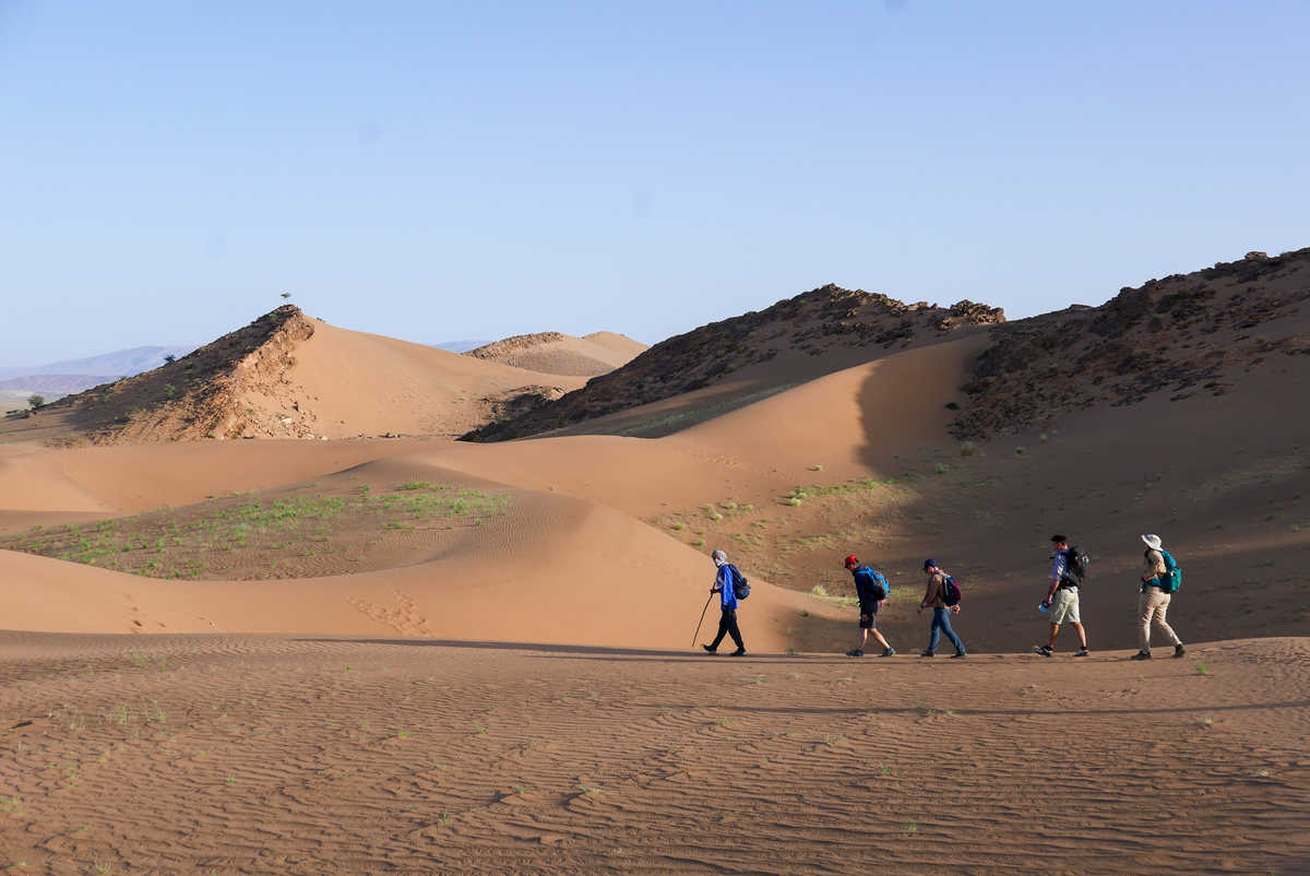 groupe de randonneurs sur une dune dans le désert au Maroc