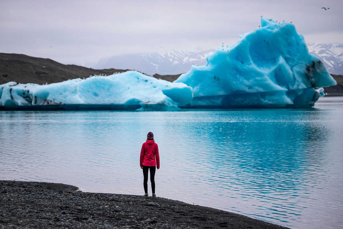 Randonneuse devant le lagon glaciaire de Jökulsárlón, Islande