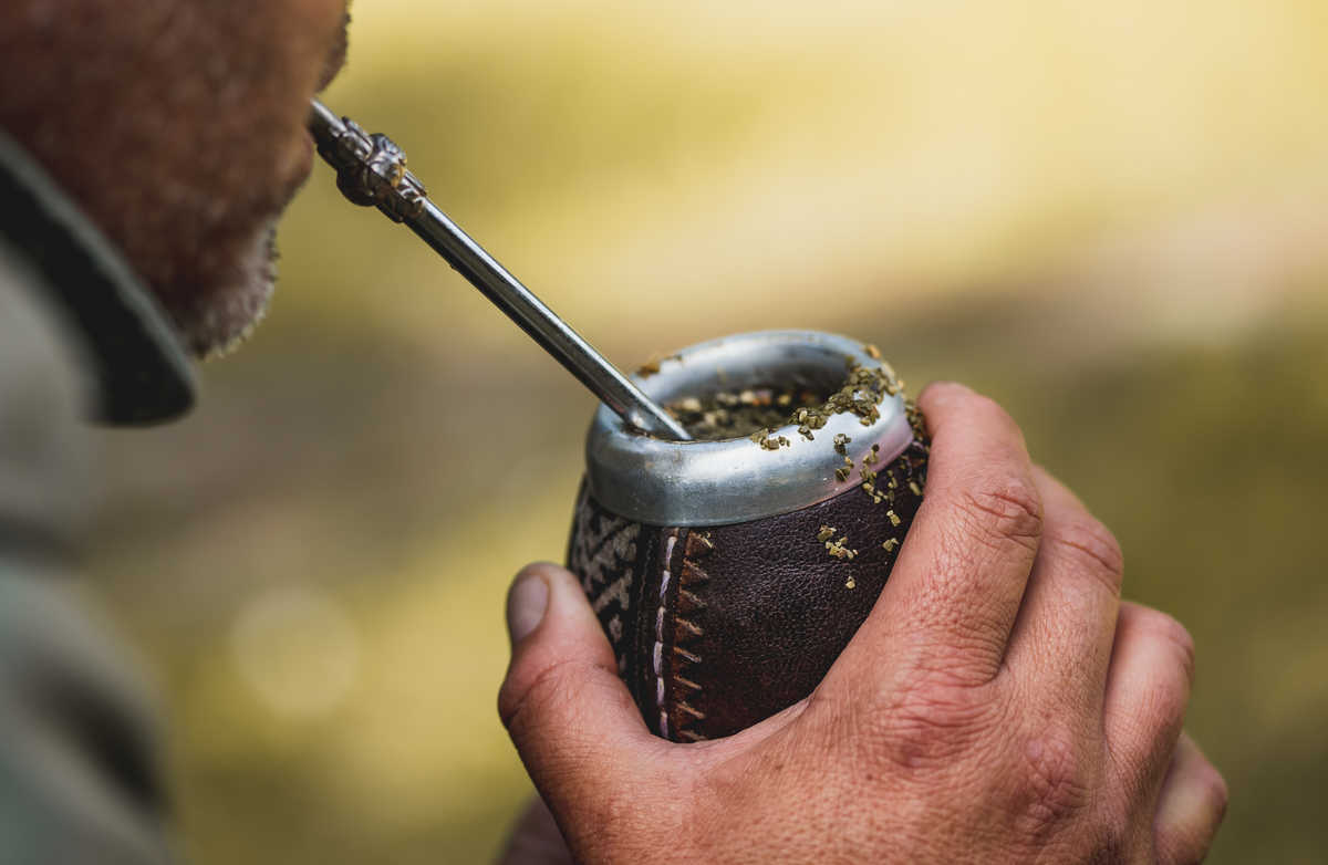 un homme boit du maté dans une calebasse