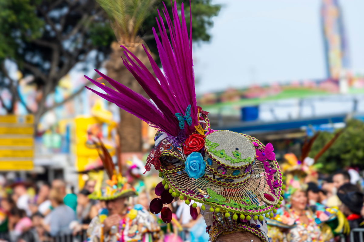 une personne portant un chapeau coloré durant le carnaval de Santa Cruz à Tenerife