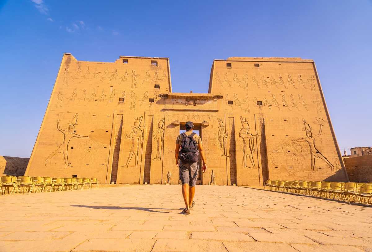 Voyageur devant le temple d'Edfou en Egypte