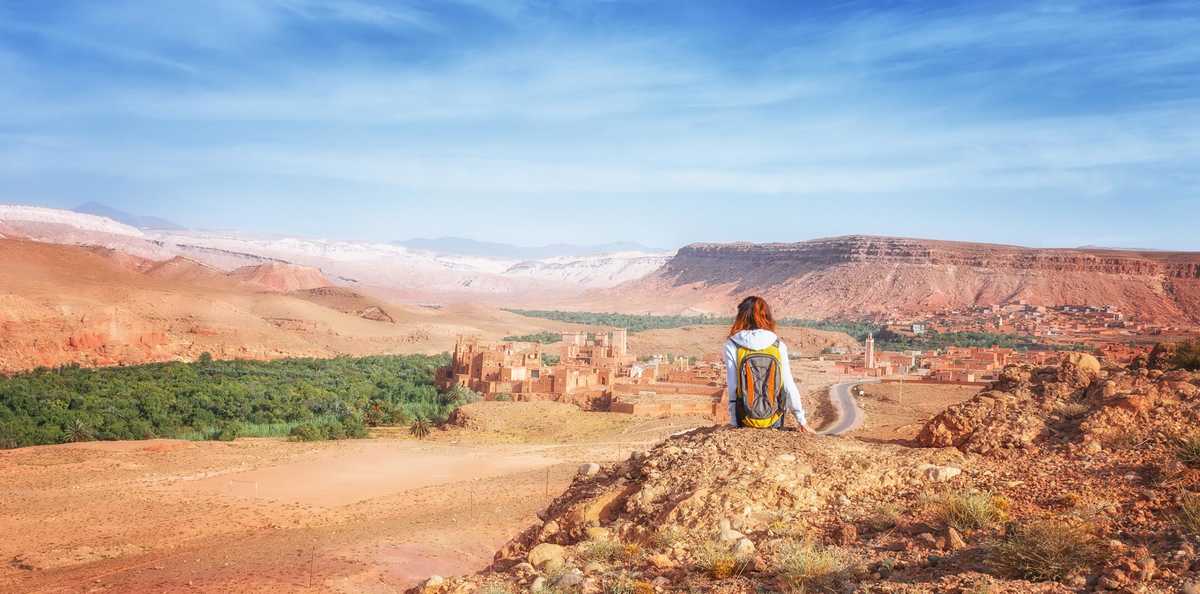 Voyageuse assise devant la vallée d'Ounila, contemplant la kasbah de Télouet au loin