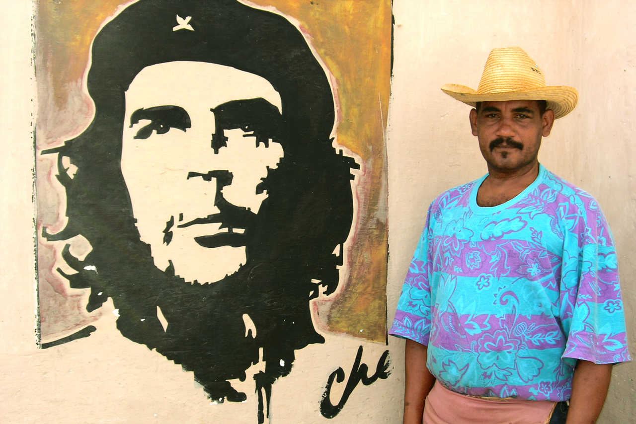 Cubain devant un portrait du Ché dans une rue de la Havane à Cuba