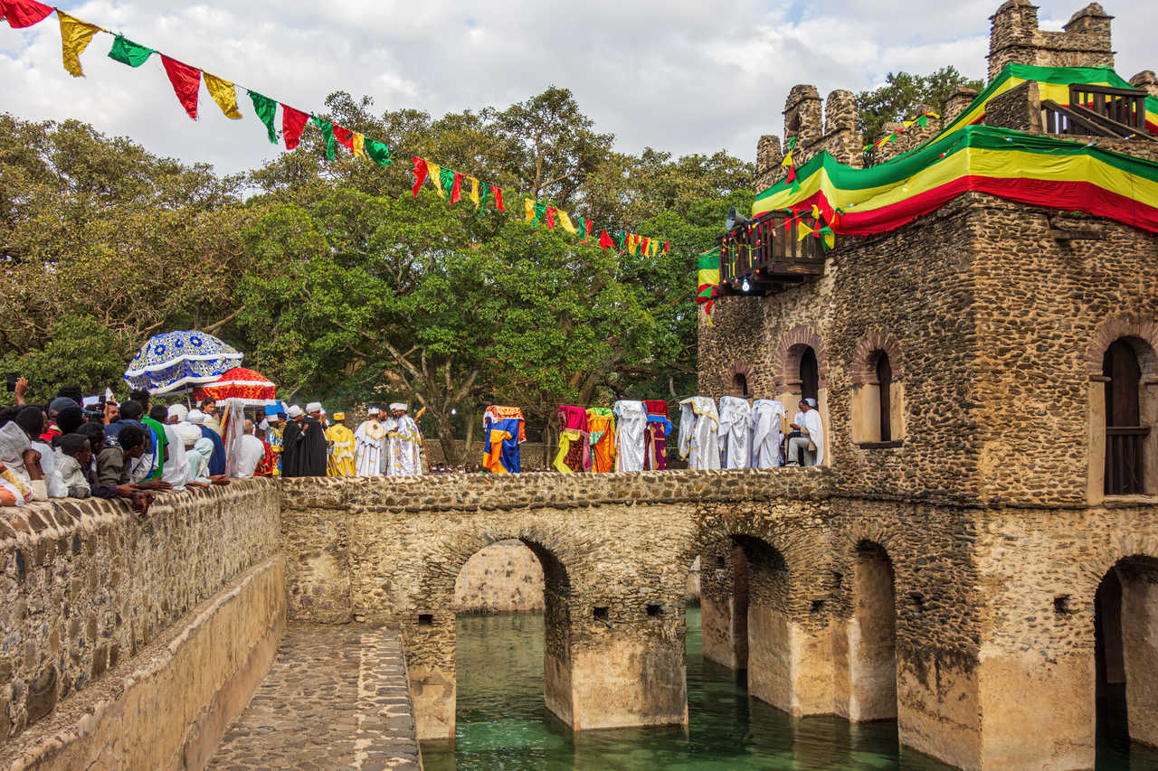Des prêtres orthodoxes éthiopiens quittant la maison de bains de Fasilides en portant le tabot durant une fête religieuse en Ethiopie © Picturific Des prêtres orthodoxes éthiopiens quittant la maison de bains de Fasilides en portant le tabot durant une fête religieuse en Ethiopie