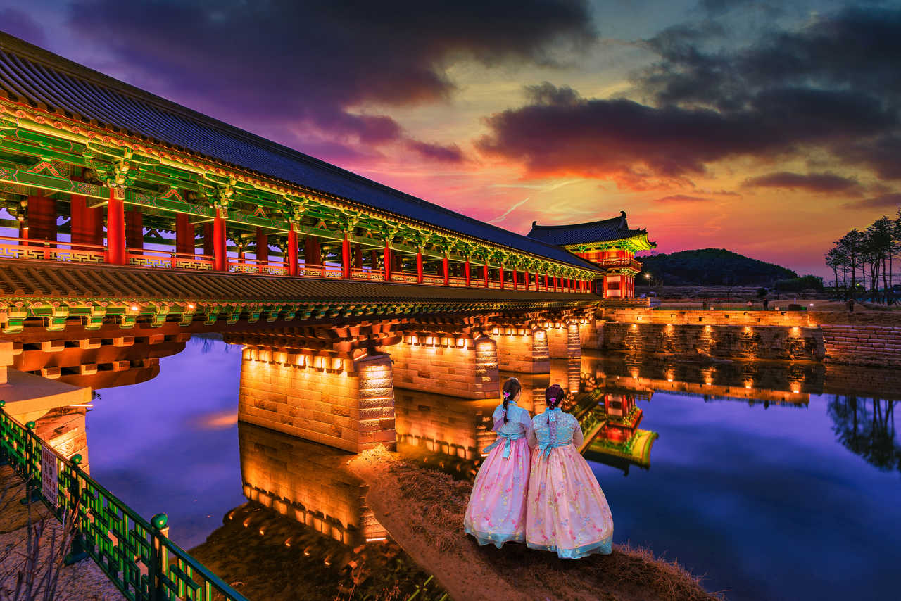 deux femmes en habits traditionnels coréen au coucher de soleil sur le pont Woljeong dans la ville de Gyeongju, en Corée du Sud.