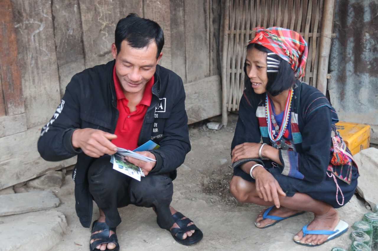 deux laotiens accroupies  dans un village au Laos