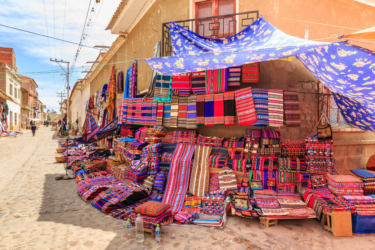Étalage de textiles artisanaux colorés au marché de Tarabuco, Bolivie