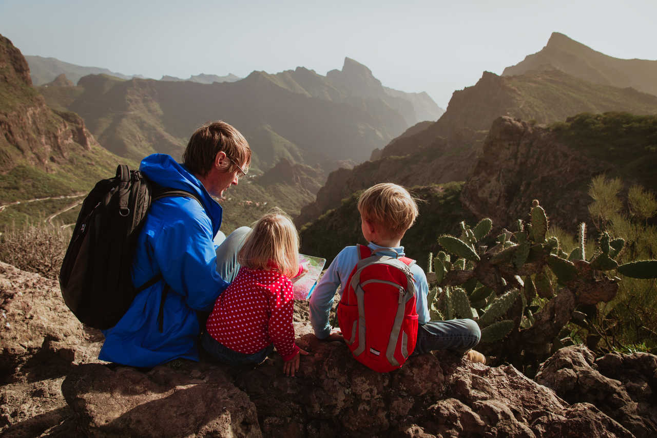 Famille en haut d'une montagne canarienne regardant une carte