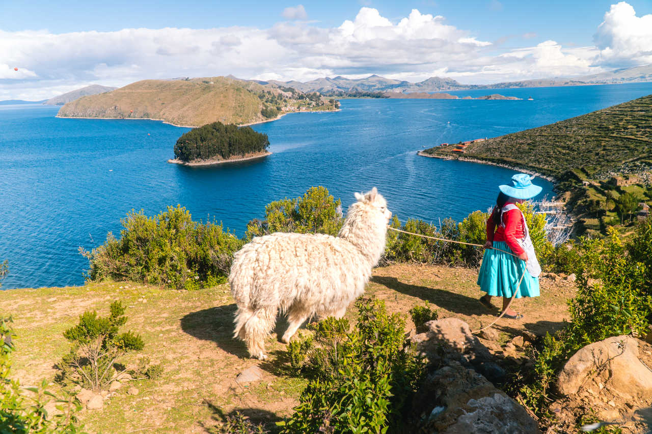 Femme en tenue traditionnelle et lama sur l'Île du Soleil, Lac Titicaca