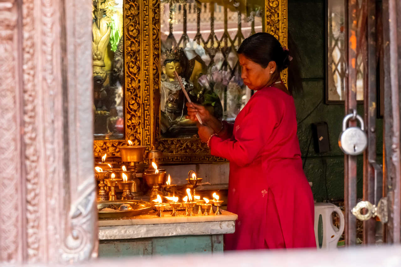 Femme népalaise qui allume des bougies à Patan au Népal